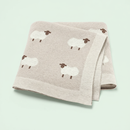 Couverture tricot bébé beige motif moutons sur fond vert pâle