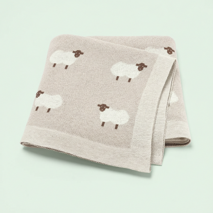 Couverture tricot bébé beige motif moutons sur fond vert pâle