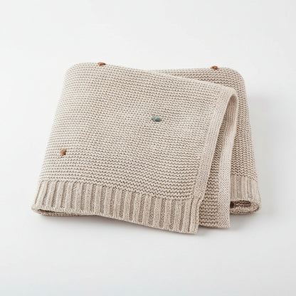 Couverture bebe tricot beige points brodés colorés fond gris clair