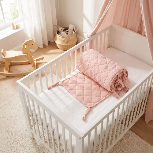 Tour de lit bebe rose enrouler dans lit blanc