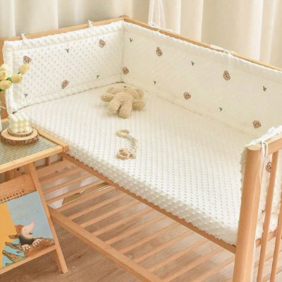 Tour de lit blanc motifs panda décoratif pour chambre bébé avec peluche dans le lit.
