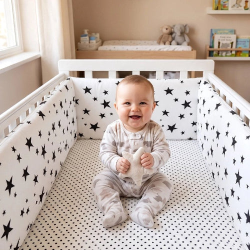 Tour de lit blanc étoiles noires bébé souriant lit