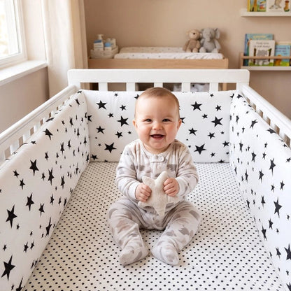 Tour de lit blanc étoiles noires bébé souriant lit
