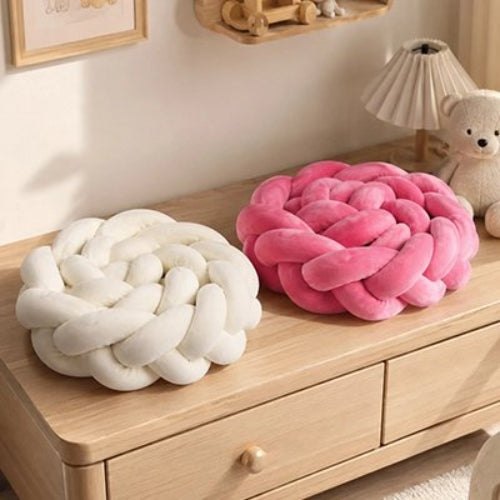 Tour de lit tresse, blanc et rose sur une commode
