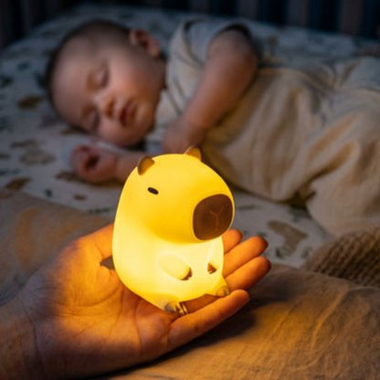 Veilleuse bébé, capybara dans la main bébé endormi
