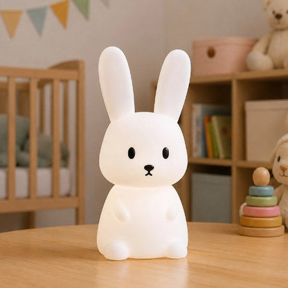 Veilleuse lapin blanche posée sur une table en bois
