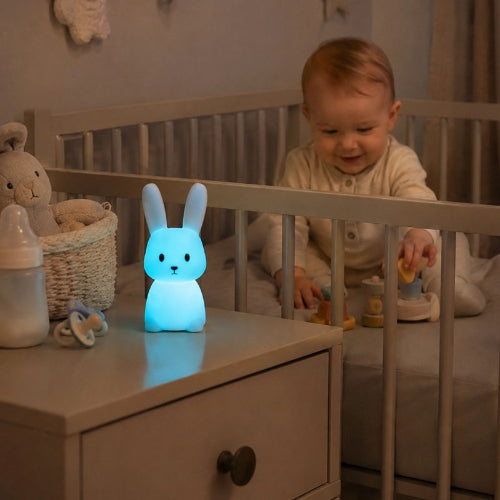 Veilleuse lapin lumière bleue qui amuse un bébé souriant