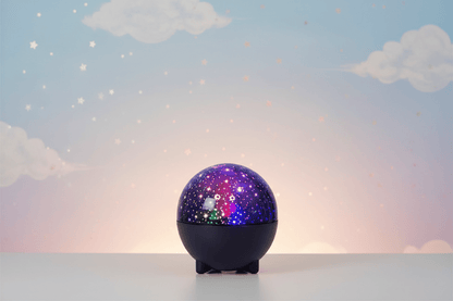 Veilleuse projection bébé en forme de sphère violette étoilée sur fond pastel doux